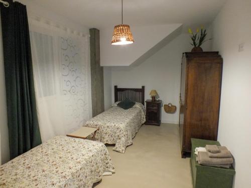 a bedroom with two beds and a chandelier at OLI VITA HOLIDAY HOME 4 O 2 PEOPLE Viveiro VUT-LU-3838 in Viveiro