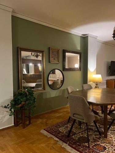a dining room with a table and two mirrors at Ines Elysium in Kastoria
