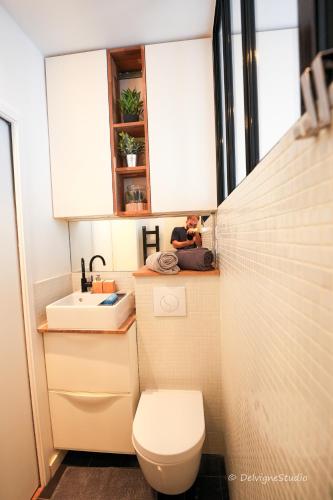 une petite salle de bain avec toilettes et lavabo dans l'établissement Appartement Design - Lumineux & Confort - 5mn de Paris, à Bagnolet