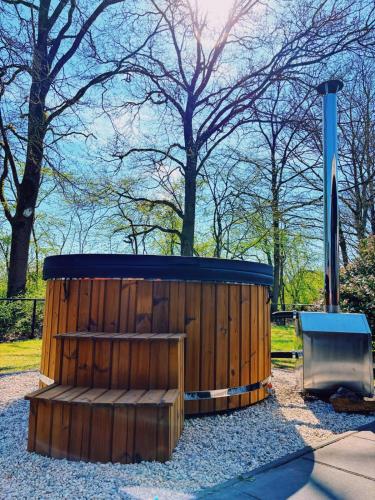 a wooden structure with a bench in a park at Bungalow Doris met Hottub | 4 personen - Vakantiepark De Kremmer in Gasselte