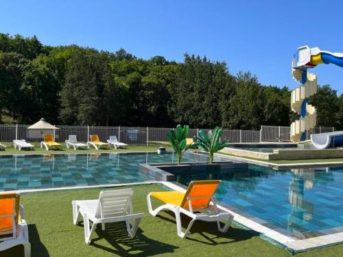 une piscine avec deux chaises et un visorvisorvisor dans l'établissement Camping Le Lizot - Aquatique Vacances, à Saint-Mandé-sur-Brédoire
