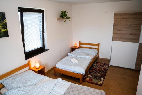 two twin beds in a room with a window at Adventure Farm in Štore