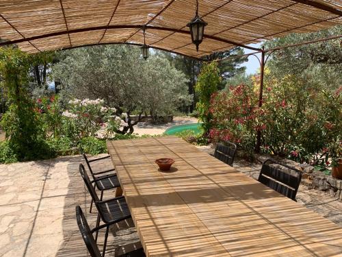une table et des chaises en bois sous un parasol en bois dans l'établissement Villa Tourmarin à Flayosc, à Flayosc