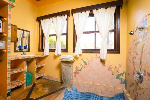a bathroom with yellow walls and a staircase with windows at Bananarama Dive & Beach Resort in West Bay