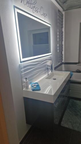 a bathroom with a white sink and a mirror at Ferienwohnung EDITH in Dobbrikow