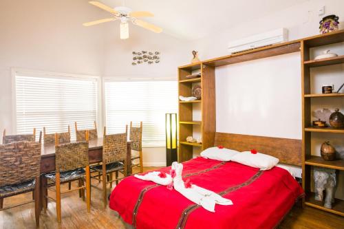 a bedroom with a red bed and a dining room at Bananarama Dive & Beach Resort in West Bay