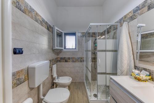 a bathroom with a toilet and a shower at Villa Elena in Marina di Pescoluse