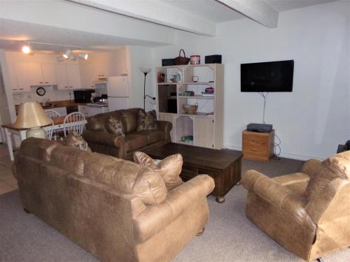 a living room with couches and a flat screen tv at Snowflake 1 Bed plus Den 2 Bath SFAF in Copper Mountain