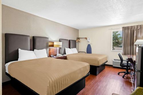 ein Hotelzimmer mit zwei Betten und einem Schreibtisch in der Unterkunft Econo Lodge Emporia in Emporia