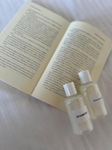 two bottles of soap sitting next to an open book at Kampos View in Ágios Nikólaos