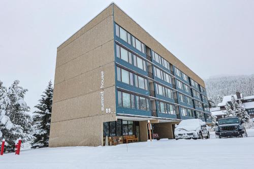a building in the snow with a truck parked in front at Summit House 2 bed 2 bath SHGW in Copper Mountain