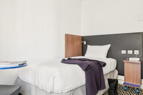 a bedroom with two beds and a table with a night stand at ibis Styles Paris République Le Marais in Paris