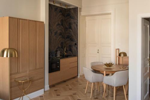 a kitchen and dining room with a table and chairs at Harmonia Palace - Luxury Apartments in Budapest
