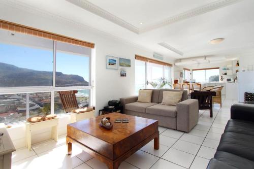 una sala de estar con un sofá y una mesa en Crow's Nest Fish Hoek Apartment, en Fish Hoek