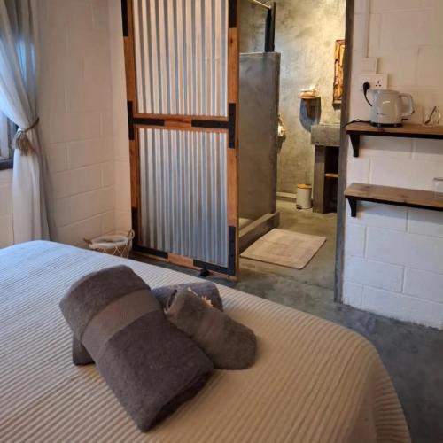 a bedroom with a bed with two pillows on it at Kot Nou - Kwizine Mama Manze Lakaz in Mahébourg