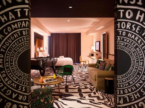 a living room with a room with a bed and a piano at Mama Shelter Belgrade in Belgrade