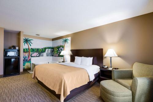 a hotel room with a bed and a chair at Quality Inn I-70 Near Kansas Speedway in Kansas City
