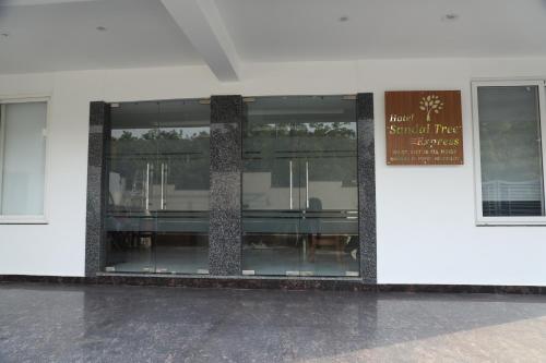 a building with glass windows and a sign on it at Hotel Sandal tree express in Noida