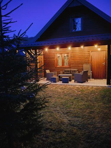 a house with a patio at night with lights at Ostoja nad potokiem Dwernik in Dwernik