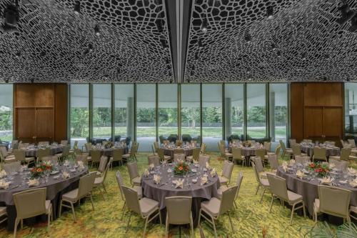 a banquet hall with tables and chairs and windows at Mandai Rainforest Resort by Banyan Tree in Singapore
