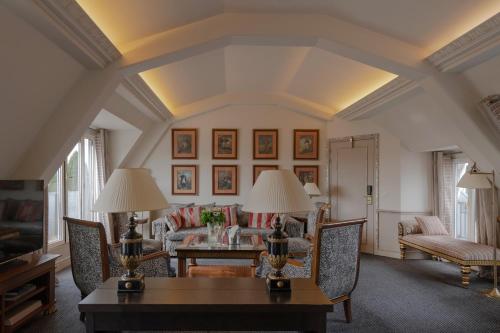 a living room with a couch and a table at Hôtel Napoleon Paris in Paris