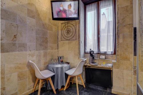 une chambre avec deux chaises, une table et une fenêtre dans l'établissement Sous mon toit - Sauna & jacuzzi, à Dijon