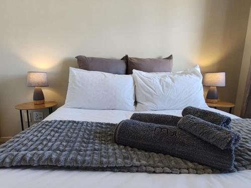 a bedroom with a bed with two pillows on it at Beach Loft Empire Apartment in Muizenberg