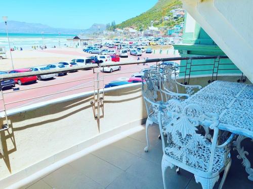 a balcony with a blue chair and a view of a beach at Sunrise Deck Empire Apartment in Muizenberg
