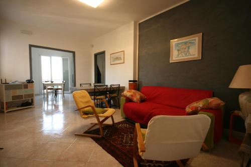 a living room with a red couch and chairs at Grazioso appartamento non lontano dal mare in Trappeto