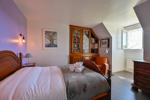 a bedroom with a large bed and a dresser at Ty Nehue - Maison avec jacuzzi in Crach