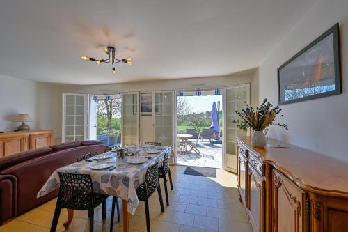 a dining room with a table and a couch at Ty Nehue - Maison avec jacuzzi in Crach