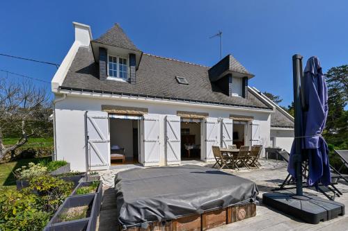 a bed in front of a house with a roof at Ty Nehue - Maison avec jacuzzi in Crach
