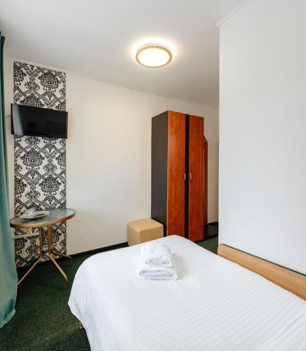 a room with a bed and a table and a cabinet at Pensiune Restaurant Căprioara Toplița in Topliţa