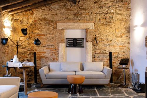 a living room with a couch and a brick wall at Land of Alandroal in Alandroal