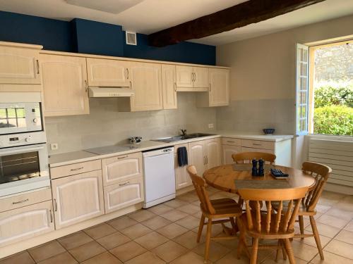 une cuisine avec des armoires blanches et une table et des chaises dans l'établissement A haven…, à Faux