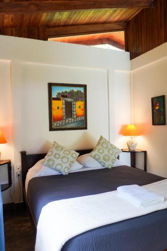 a bedroom with a large bed with two lamps at Sueño Río Celeste Boutique B&B in Bijagua