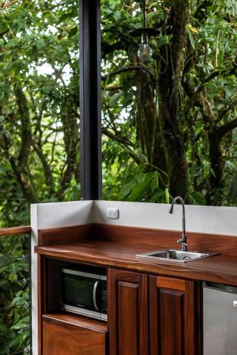a kitchen with a sink and a window at Sueño Río Celeste Boutique B&B in Bijagua