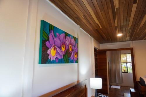 a painting of flowers on the wall of a room at Sueño Río Celeste Boutique B&B in Bijagua