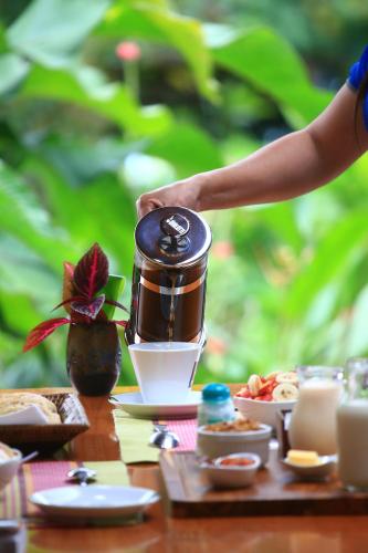 a table with a coffee maker on a table with food at Sueño Río Celeste Boutique B&B in Bijagua