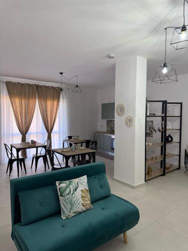un soggiorno con un divano verde e una sala da pranzo di Tropical House a Gizzeria