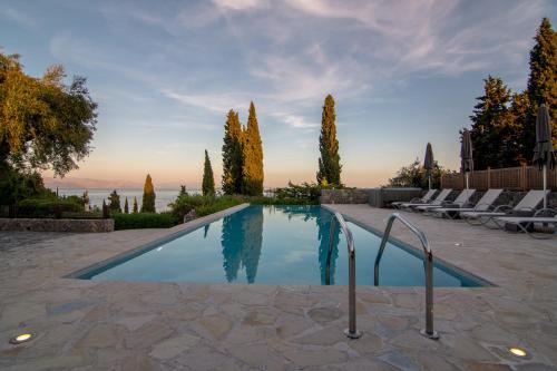a swimming pool in a yard with chairs and trees at Villa Naldera in Kommeno