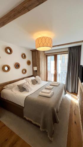 une chambre avec un grand lit dans une pièce dans l'établissement Résidence KILIMANDJARO - appt 3 pièces 60m2 - by Hotel MontBlanc, à Val dʼIsère