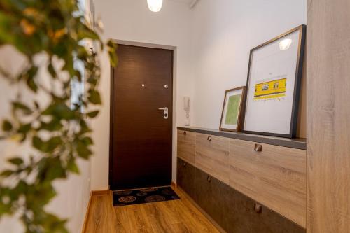 a hallway with a wooden door and a mirror at Downtown Loft Apartment with Jacuzzi&Terrace in Bucharest