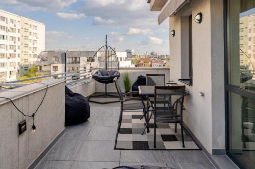 a balcony with chairs and a table on a building at Downtown Loft Apartment with Jacuzzi&Terrace in Bucharest