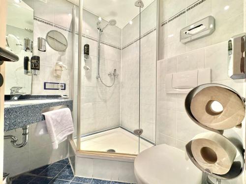 a bathroom with a toilet and a glass shower at AR Boutique Hotel Mannheim in Mannheim