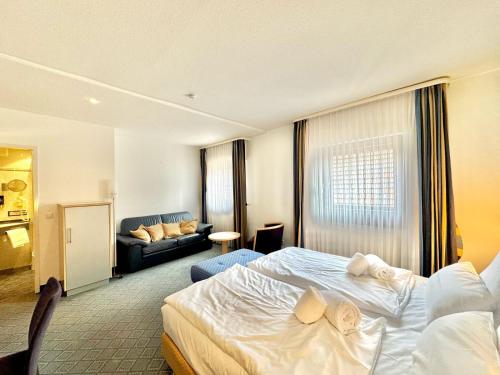 a hotel room with a bed and a couch at AR Boutique Hotel Mannheim in Mannheim