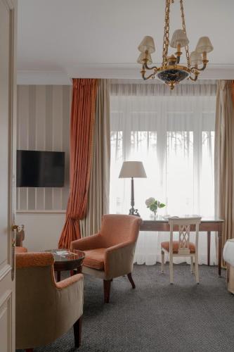 a living room with a chair and a table at Hôtel Napoleon Paris in Paris