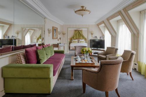 a living room with a couch and a table at Hôtel Napoleon Paris in Paris
