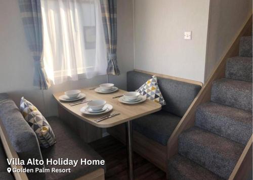 a small room with a table and chairs and a staircase at Golden Palm Resort in Chapel Saint Leonards