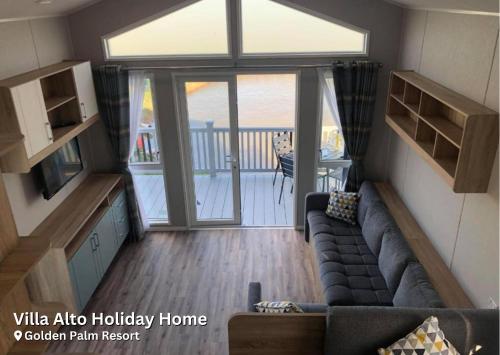 a living room with a couch and a sliding glass door at Golden Palm Resort in Chapel Saint Leonards
